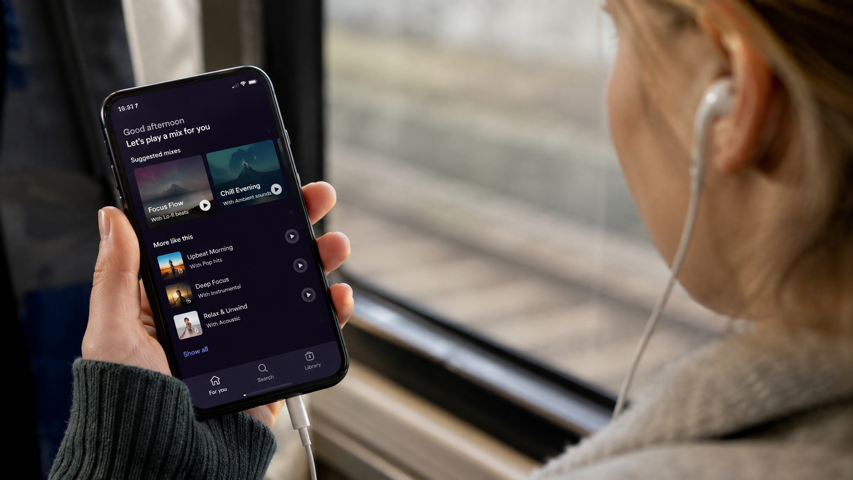 Listener using a phone to browse suggested mixes based on personal preferences, illustrating algorithmically personalized playlists.